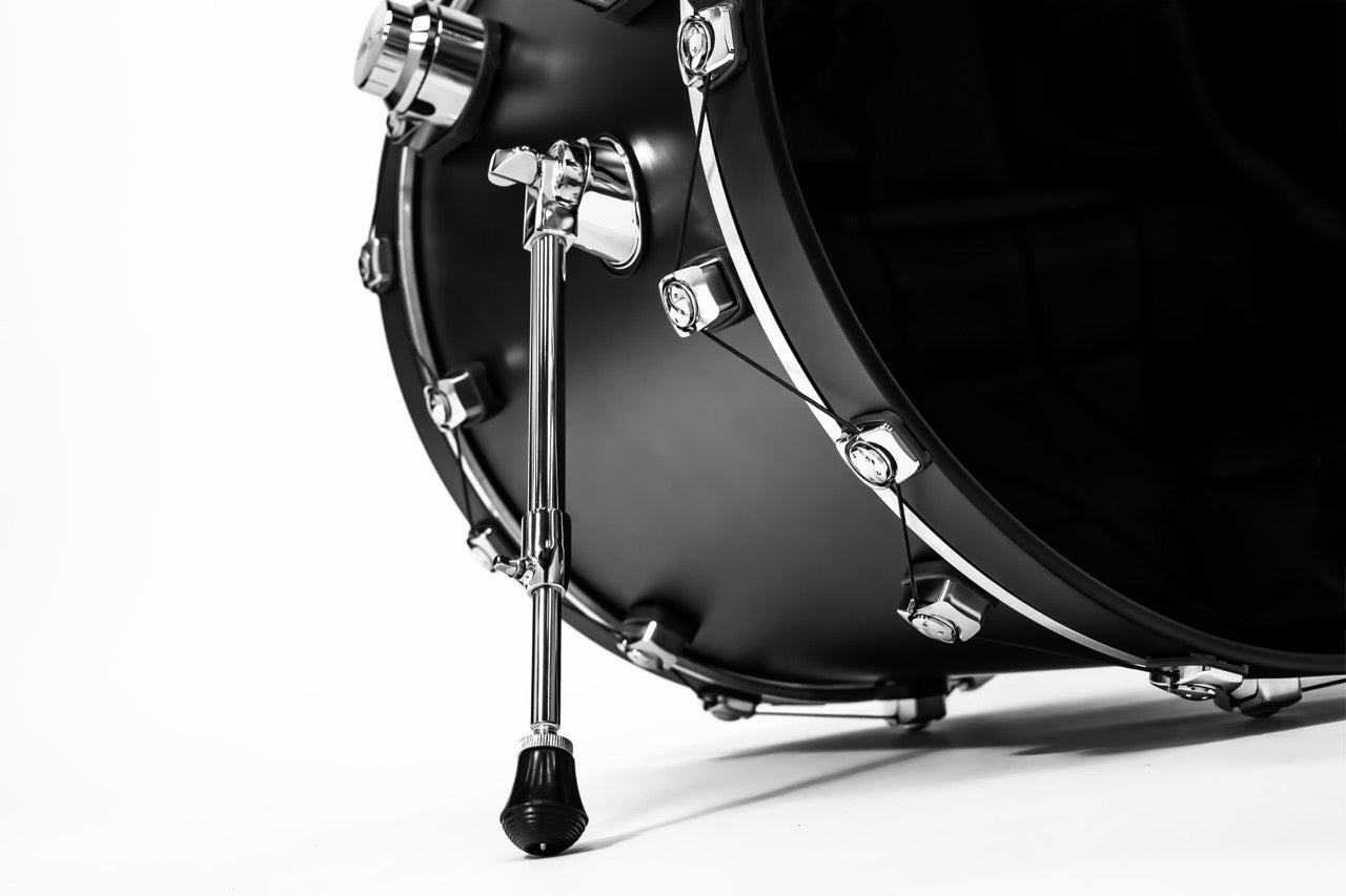 Close-up of a black bass drum with chrome hardware on a white background
